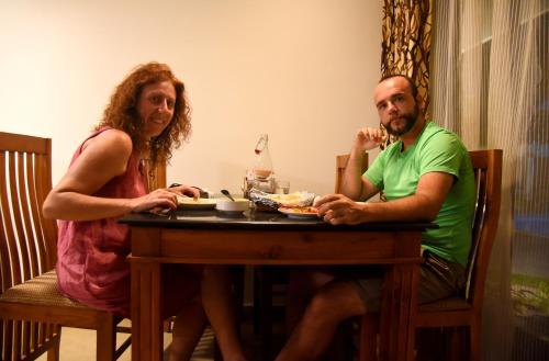 a man and a woman sitting at a table at Marari Green Villas in Mararikulam