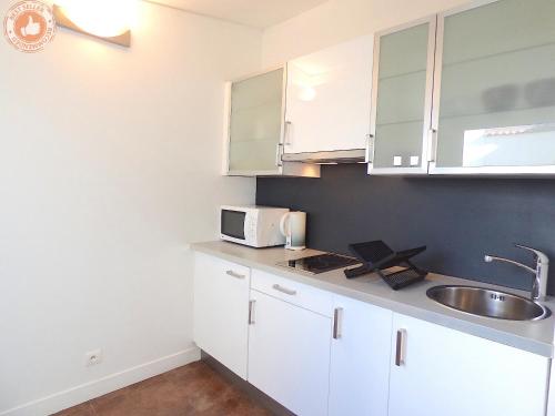 une cuisine avec des armoires blanches et un évier dans l'établissement ALC - JJ481 - 9 min Palais and Beaches, à Cannes