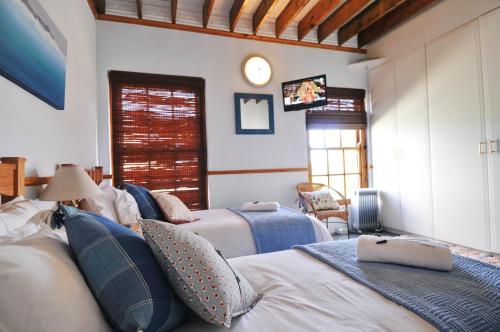 a bedroom with two beds and a tv on the wall at Peace Valley Guesthouse in Napier