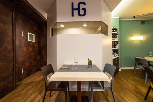 a dining room with a white table and chairs at Hotel Gardenia in Romano Canavese
