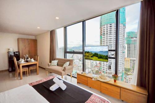 a bedroom with a large window with a view of a city at Holi Beach Hotel & Apartments in Nha Trang