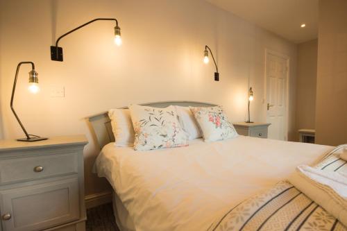 a bedroom with a bed with two lamps on it at Tissington Cottage- Darwin Lake Holiday Village in Matlock