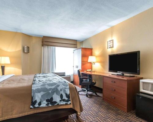 a hotel room with a bed and a flat screen tv at The Douillet by Demeure Hotels in Oklahoma City