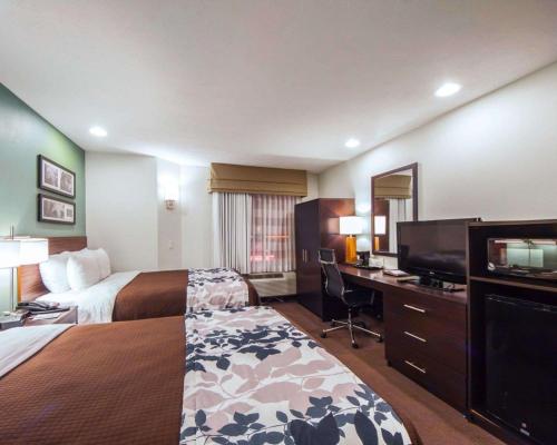 a hotel room with two beds and a desk at Sleep Inn & Suites Edmond near University in Edmond
