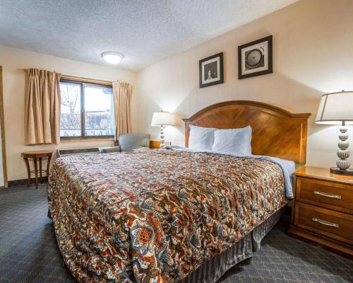 a hotel room with a bed and a window at Rodeway Inn in Baker City