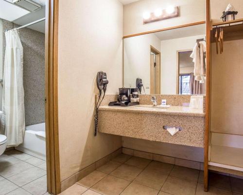 bagno con lavandino e specchio di Rodeway Inn Baker City a Baker City