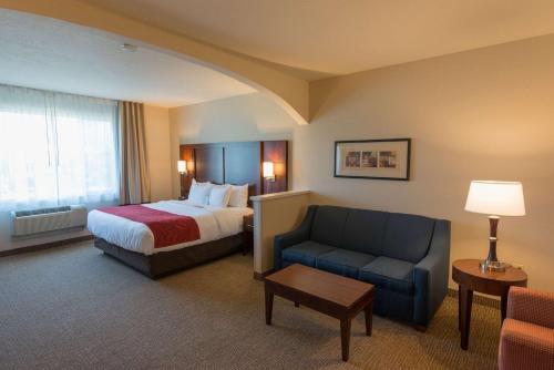 Habitación de hotel con cama y silla en Comfort Suites Springfield RiverBend Medical, en Springfield