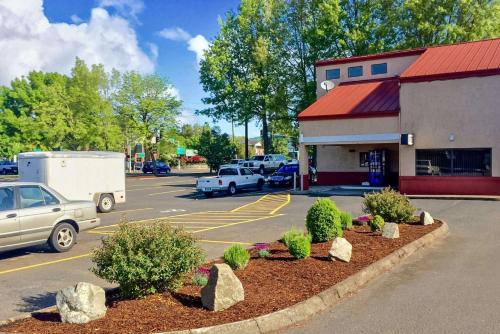 a gas station with cars parked in a parking lot at Rodeway Inn Willamette River in Corvallis