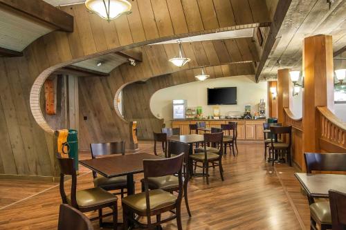 a restaurant with wooden walls and tables and chairs at Quality Inn & Suites at Coos Bay in North Bend
