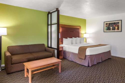 a hotel room with a bed and a couch at Quality Inn & Suites at Coos Bay in North Bend