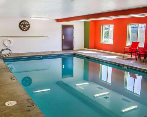 una gran piscina con sillas rojas en una habitación en Sleep Inn & Suites Roseburg North Near Medical Center, en Roseburg