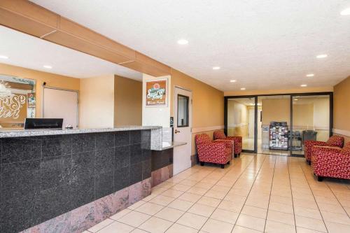 a lobby of a hospital with red chairs and a counter at Bridgeway Inn & Suites in Sublimity