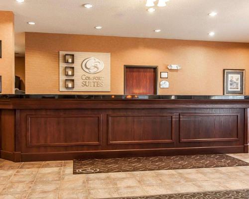 a hotel lobby with a large wooden reception desk at Comfort Suites Redmond Airport in Redmond