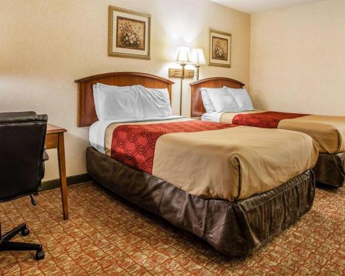 a hotel room with two beds and a desk at Econo Lodge Douglassville-Pottstown in Douglassville