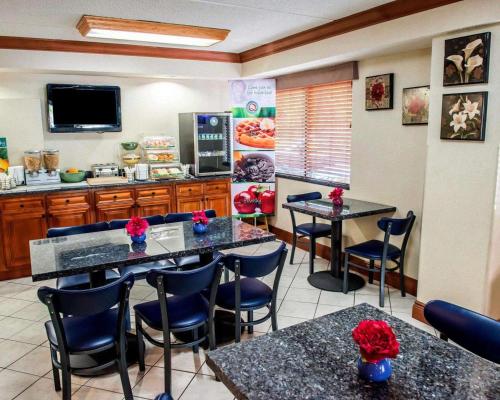 a restaurant with tables and chairs and a kitchen at Quality Inn & Suites North Gibsonia in Gibsonia