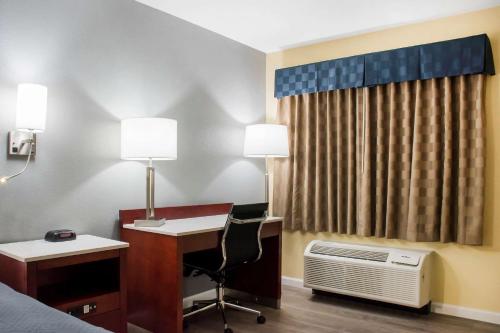 a hotel room with a desk and a bed and a computer at Escape Inn Hershey in Hershey