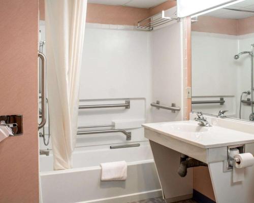 a bathroom with a sink and a bath tub at Econo Lodge Drums in Drums