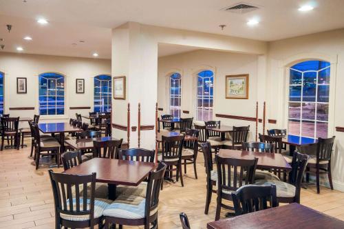 a restaurant with tables and chairs and windows at Comfort Inn Amish Country in New Holland