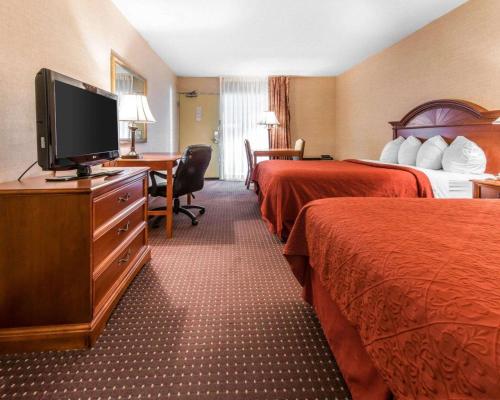 a hotel room with two beds and a flat screen tv at Quality Inn & Suites Erie near Casino in Erie