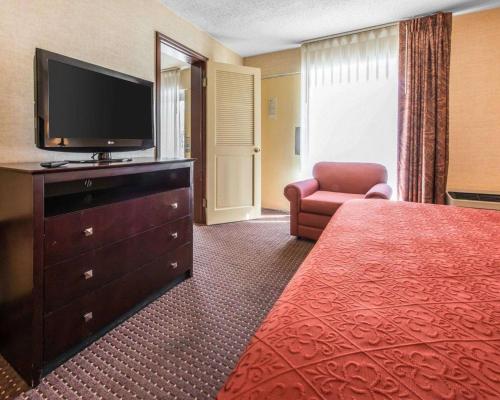 a hotel room with a bed and a flat screen tv at Quality Inn & Suites Erie near Casino in Erie