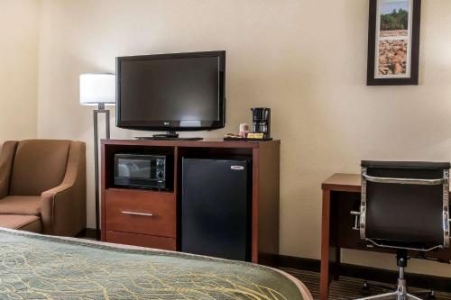 a hotel room with a flat screen tv and a chair at Comfort Inn - Pocono Mountains in White Haven