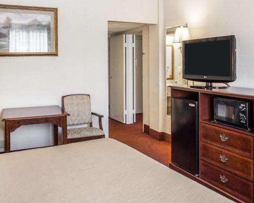 a hotel room with a bed and a flat screen tv at Quality Inn & Conference Center Franklin Downtown in Franklin