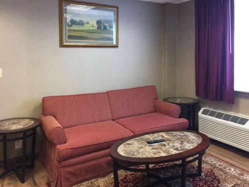 a living room with a red couch and two tables at Quality Inn & Conference Center Franklin Downtown in Franklin
