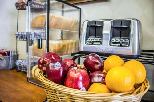 une corbeille de fruits sur un comptoir avec du pain et des oranges dans l'établissement Econo Lodge, à Meadville