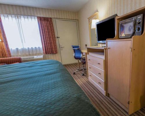 a hotel room with a bed and a flat screen tv at Quality Inn Barkeyville in Barkeyville