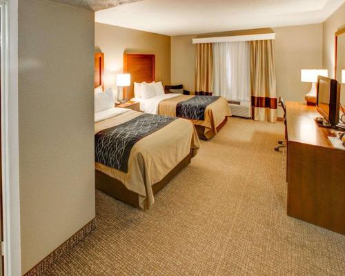 a hotel room with two beds and a desk at Comfort Inn Conference Center in Churchill