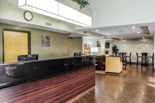 a lobby with a waiting area with a clock on the wall at Sleep Inn & Suites Bensalem in Bensalem