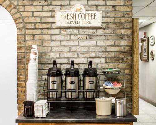 a shelf with four bottles of coffee on a brick wall at Quality Inn & Conference Center Franklin Downtown in Franklin