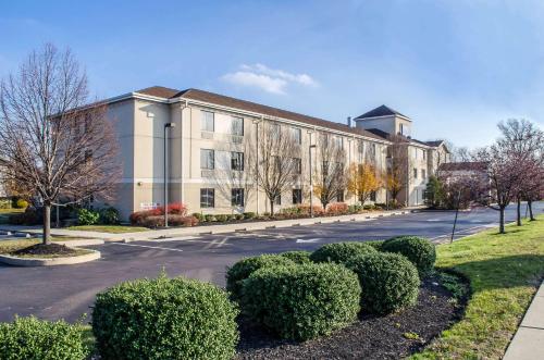 a large building with bushes in front of a street at Sleep Inn & Suites Bensalem in Bensalem