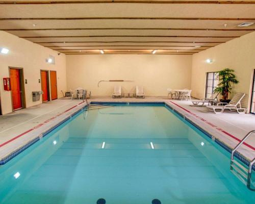 a large swimming pool with blue water in a building at Comfort Suites Pittsburgh Airport in Coraopolis
