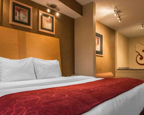 a bedroom with a large bed with a red blanket at Comfort Suites Monroeville - Pittsburgh East in Monroeville