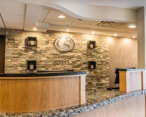 a lobby with a stone wall and a bar at Comfort Suites Monroeville - Pittsburgh East in Monroeville