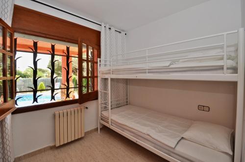 リョレート・デ・マルにあるVilla Europa C061の二段ベッド1組と窓が備わる客室です。