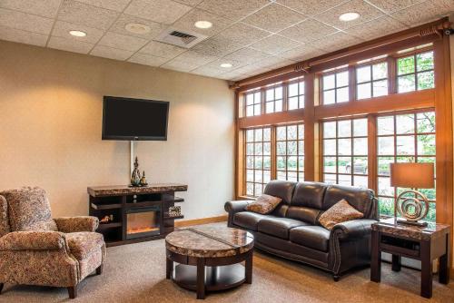 a living room with a couch and a tv at Quality Inn Pittsburgh Airport in Oakdale