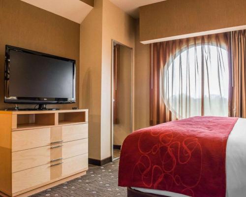 a bedroom with a bed and a flat screen tv at Comfort Suites Monroeville - Pittsburgh East in Monroeville