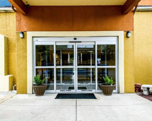 a glass door of a building with two potted plants at Econo Lodge Harrisburg - Hershey North in Harrisburg