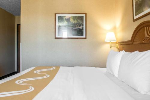 a large bed in a hotel room with a white bedspread at Quality Inn Meadville in Meadville