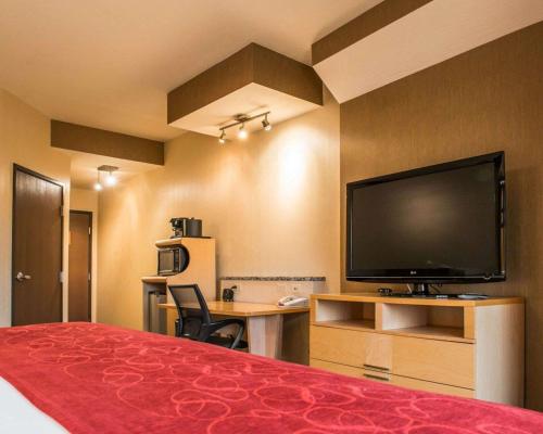 a hotel room with a bed and a flat screen tv at Comfort Suites Monroeville - Pittsburgh East in Monroeville