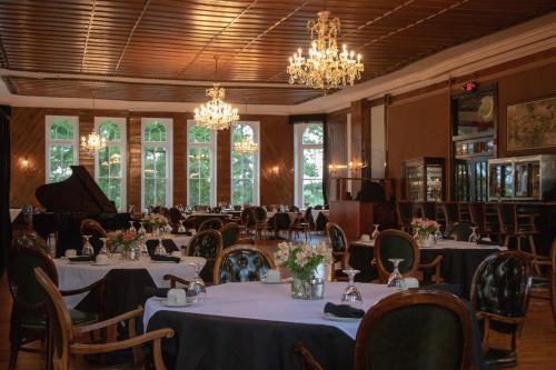 uma sala de jantar com mesas e um piano de cauda em 1886 Crescent Hotel and Spa em Eureka Springs