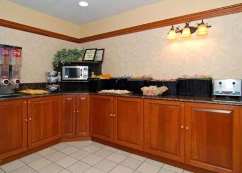 a kitchen with wooden cabinets and a counter top at Quality Inn & Suites Bensalem in Bensalem