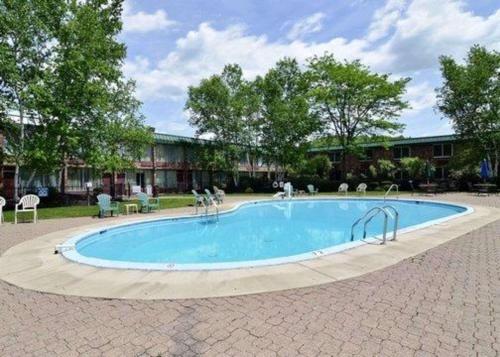a large swimming pool in a courtyard with trees at Hotel Veranda DuBois in DuBois