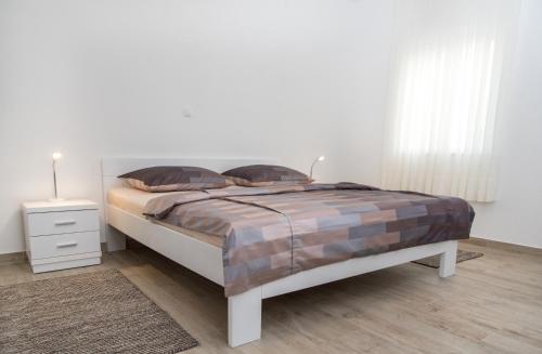 a bedroom with a bed and a night stand at Apartments Lavanda in Vinišće