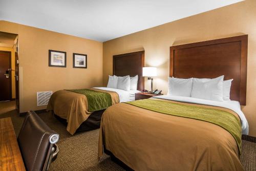 a hotel room with two beds and a chair at Quality Inn & Suites Towanda in Towanda