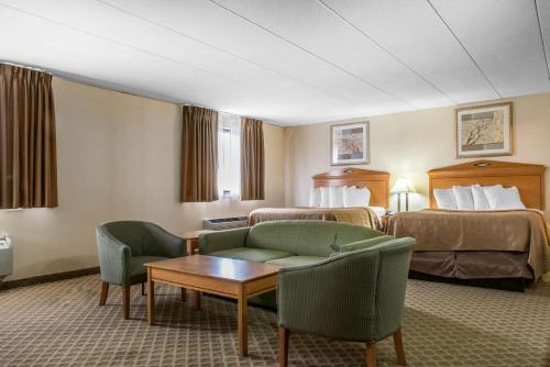 a hotel room with two beds and a couch and a table at Quality Inn & Suites in Fairview