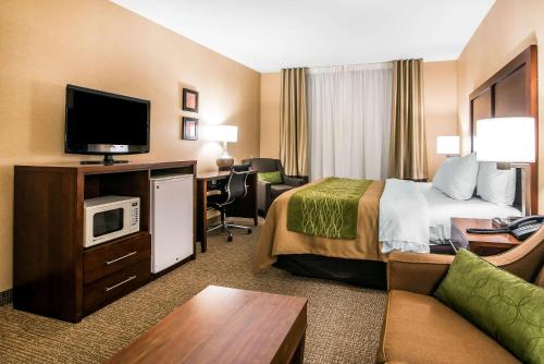a hotel room with a bed and a flat screen tv at Quality Inn & Suites Towanda in Towanda