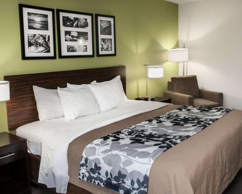 a hotel room with a large bed and a chair at Sleep Inn & Suites Harrisburg - Hershey North in Harrisburg